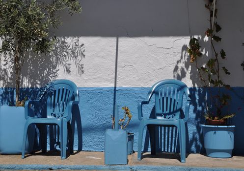 gorgeous greek scene with blue chairs (olive tree on the left)