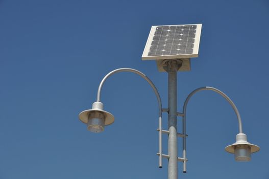 street lamp post with solar panel energy (against blue sky background)
