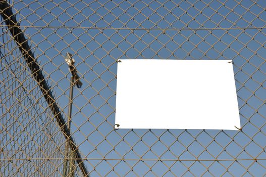 empty placard hanging on a sports court wire fence