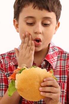 boy eating a big hamburger close up 