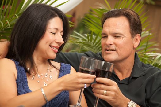 Attractive Hispanic and Caucasian Couple Drinking Wine Outside.