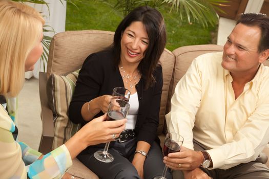 Three Friends Enjoying Wine on an Outdoor Patio.