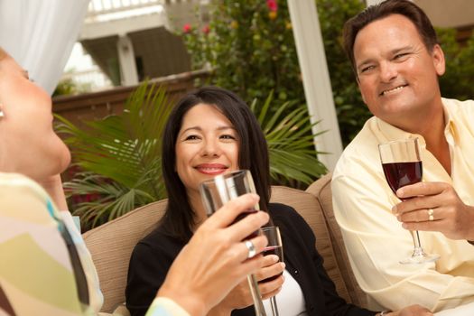 Three Friends Enjoying Wine on an Outdoor Patio.