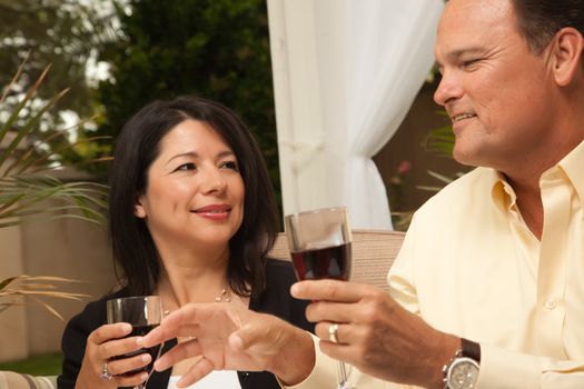 Hispanic Woman and Caucasian Man Enjoying Wine on the Patio.