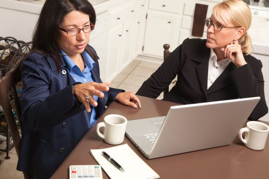 Businesswomen Working on the Laptop Together in the Kitchen.