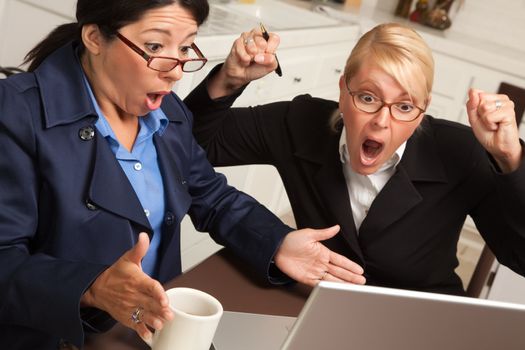 Businesswomen Celebrate Success on the Laptop in the Kitchen.