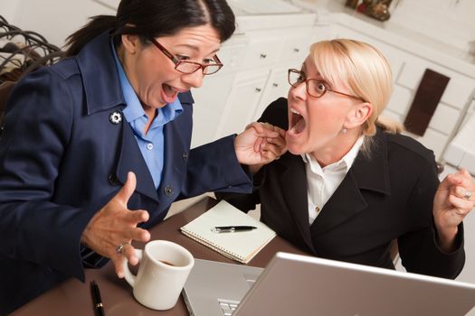 Businesswomen Celebrate Success on the Laptop in the Kitchen.