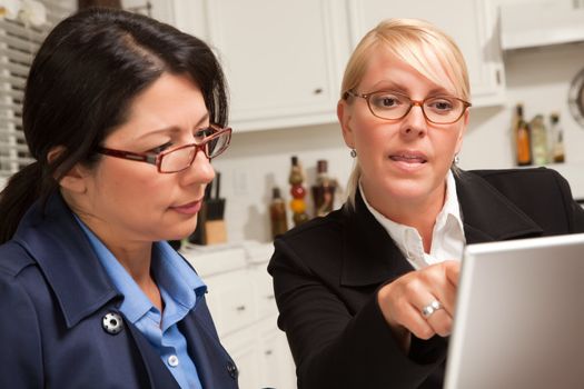 Businesswomen Working on the Laptop Together in the Kitchen.