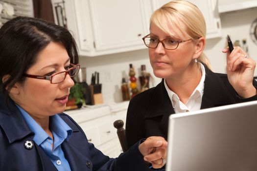 Businesswomen Working on the Laptop Together in the Kitchen.