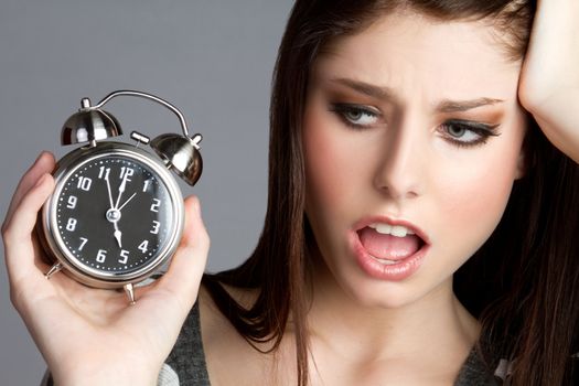 Annoyed woman holding alram clock