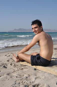 smiling young man relaxing at Kos beach in Greece (blue sky)