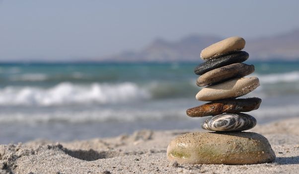 beautiful pebble stack on a sandy beach (sea on the background)