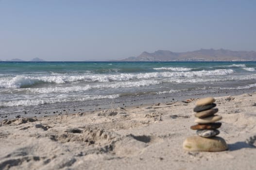 beautiful Kos beach with defocused pebble stack, Greece (Turkey on background)