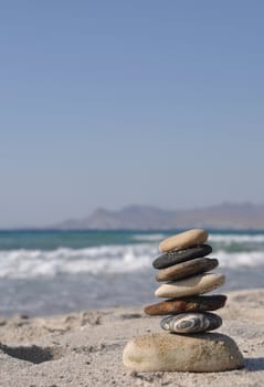 beautiful pebble stack on a sandy beach (sea on the background)