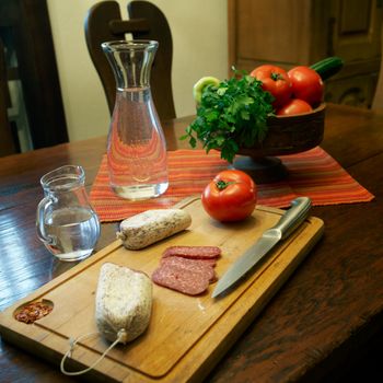 Flat sausage and fresh fruits on a wooden table