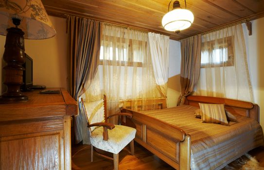 Bedroom with old style wooden furniture, hotel room interior