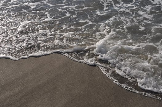 gorgeous beach sand and sea foam at sunset (copy-space available)