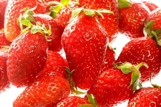 Red strawberries isolated on white surface close-up