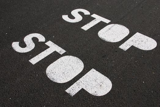 stop signs painted on a asphalt road surface

