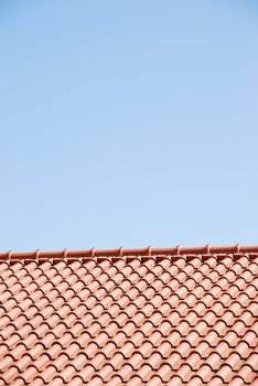 orange tiles on the roof of a house against blue sky background