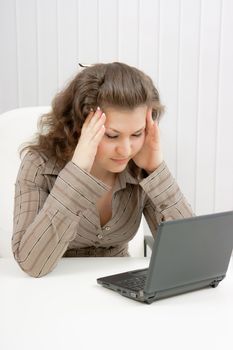 girl with laptop suffers from headaches. Office
