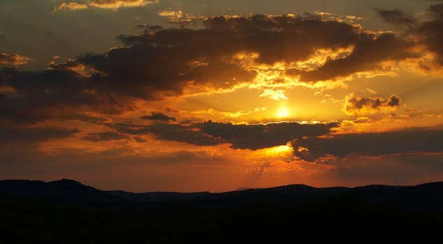 Red cloudy sunset over the mountains