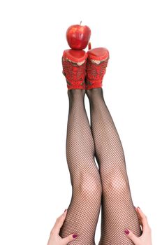 female legs in red shoes keep apple isolated on white background