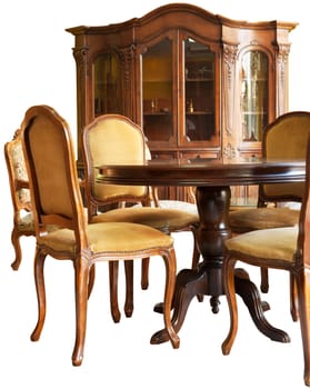 Old classic wooden furniture - a bookshelf, a table and chairs, all with handmade woodcarvings, isolated