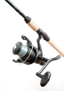 Black fishing reel, mounted on a fishing rod