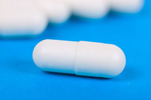 Macro view of white pill on a blue background