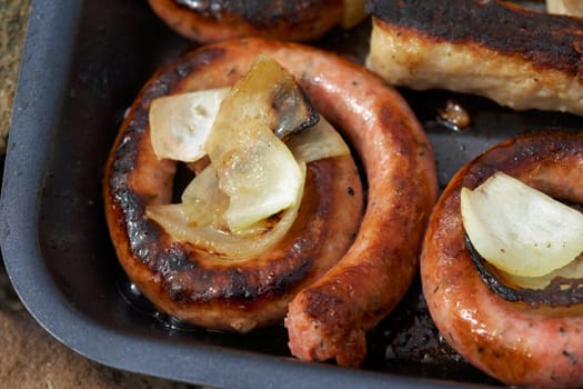 Baked sausage with onion on a grill