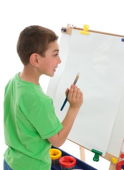 A boy with paintbrush in hand ready to paint