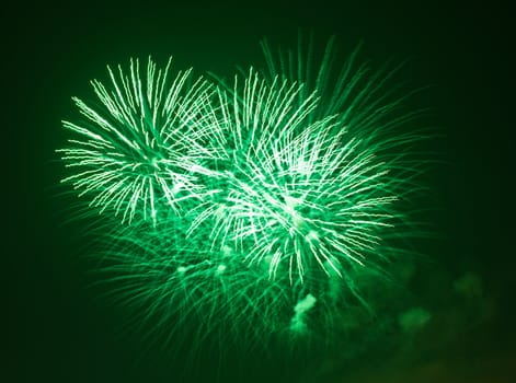 green fireworks explode at night