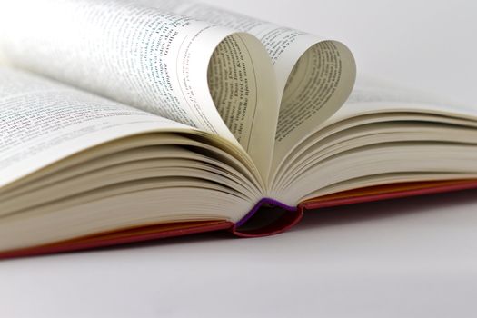 Book with pages arranged as a heart or two swans facing each other.