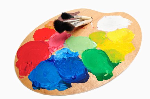 Three paintbrush through the hole on the artist palette