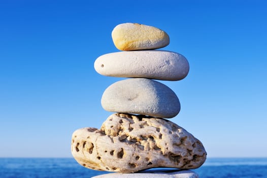 Balancing several cobble-stones on each other on the shore