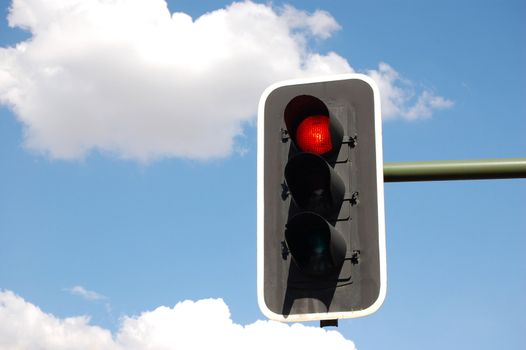 Red traffic light on perfect sky background