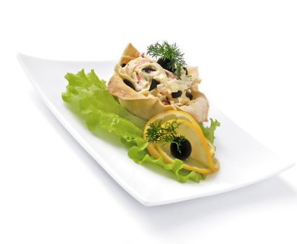 Salad with crab meat, egg, olives, mayonnaise in a basket isolated