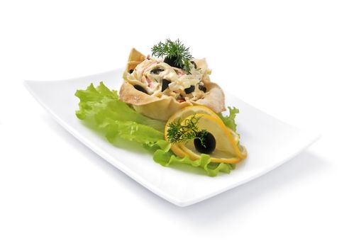 Salad with crab meat, egg, olives, mayonnaise in a basket isolated