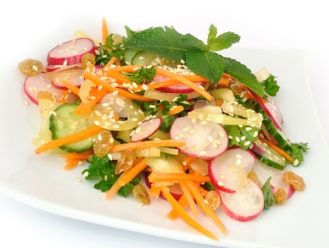 A salad of carrot, radish, cucumber, raisins, sesame and herbs