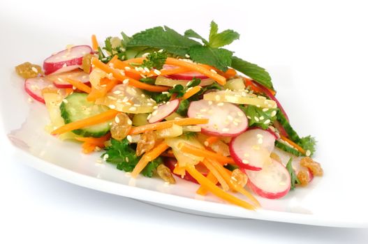 A salad of carrot, radish, cucumber, raisins, sesame and herbs