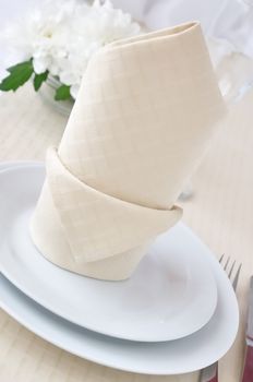 Coordinated decorative napkin on a plate with cutlery