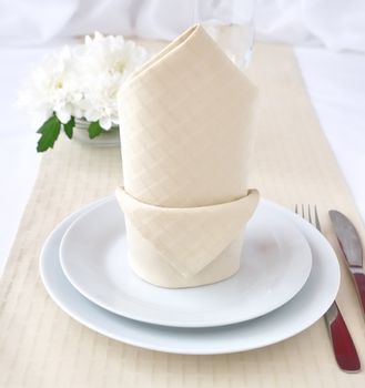 Coordinated decorative napkin on a plate with cutlery