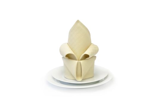 Napkin folded decoratively on a plate isolated