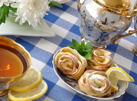 Rosettes of the apples and dough with powdered sugar to the tea table