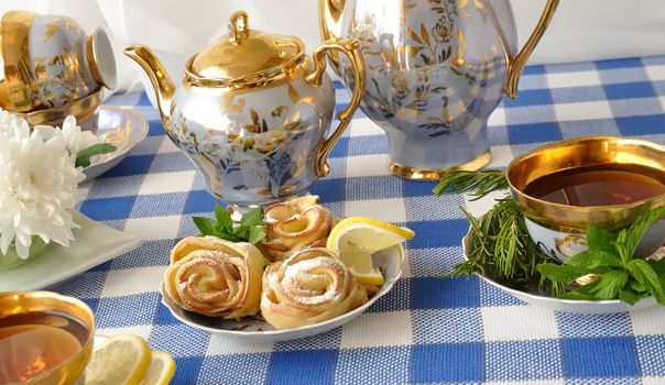 Rosettes of the apples and dough with powdered sugar to the tea table