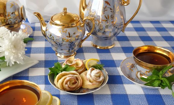 Rosettes of the apples and dough with powdered sugar to the tea table