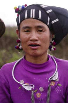 Portrait of a young woman of ethnic LU. She has black teeth, a sign that she is married. She wears her beautiful costumes