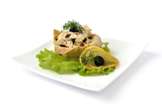 Salad with crab meat, egg, olives, mayonnaise in a basket isolated