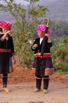 Two young women returning from the fields. Their dress is not folklore they wear daily to work